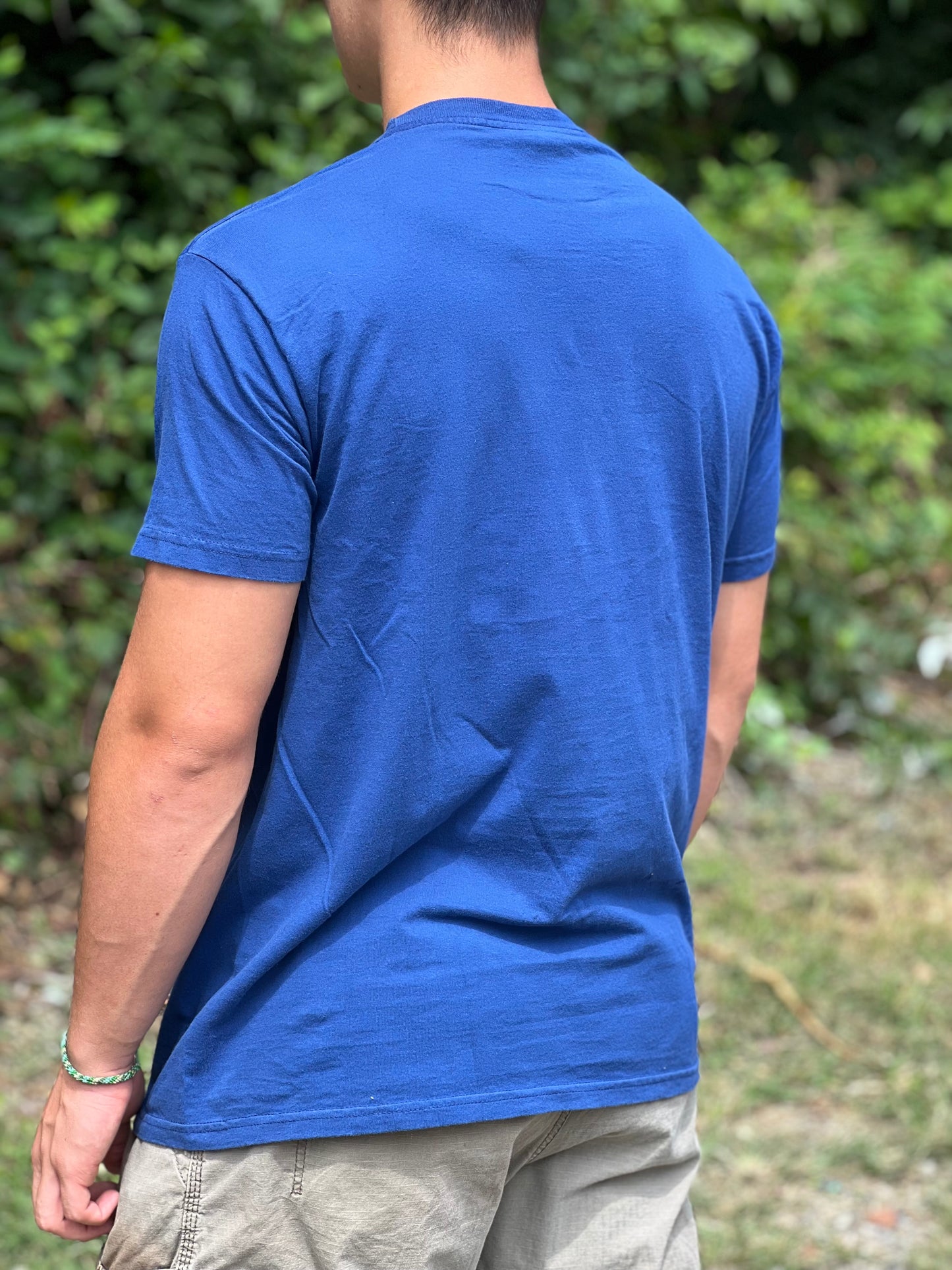 Person wearing a blue t-shirt with a blurred background