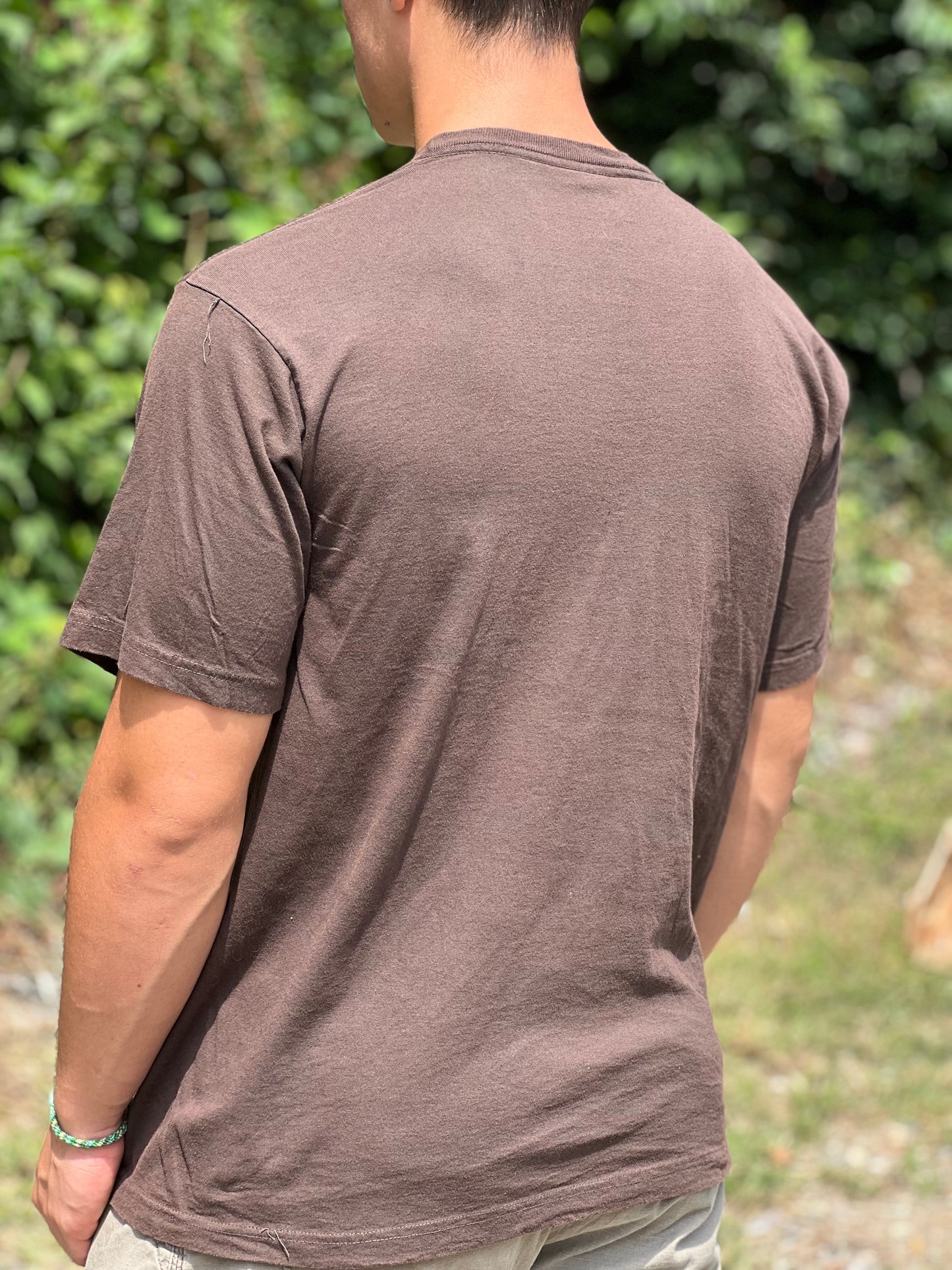 Buff male wearing a size large organic brown T-shirt standing ourdoors