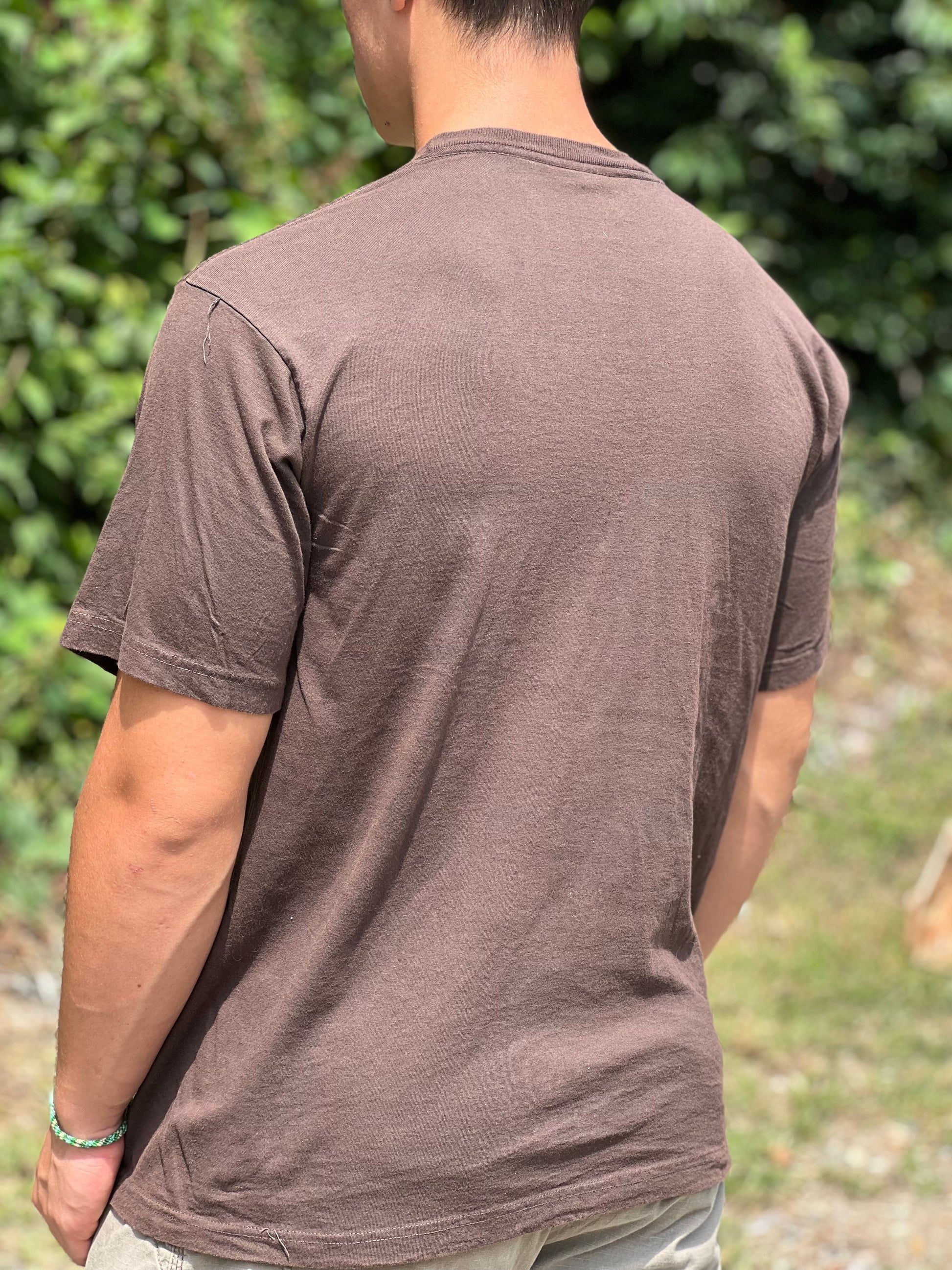 Buff male wearing a size large organic brown T-shirt standing ourdoors 